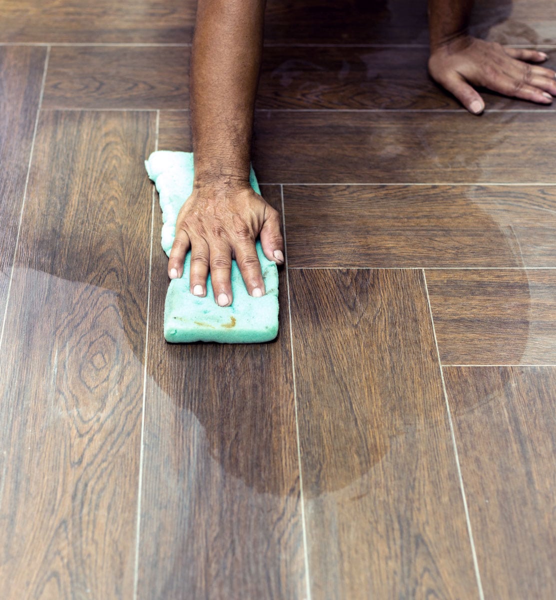 hand on the floor in the middle of a tile and grout cleaning in Reston