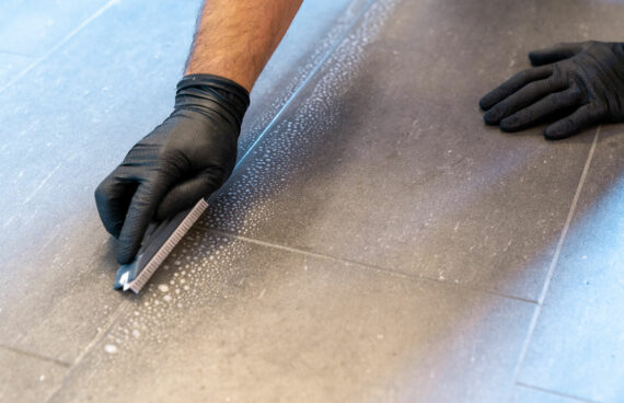 a man with black gloves providing Grout Cleaning Services in North Potomac, Maryland