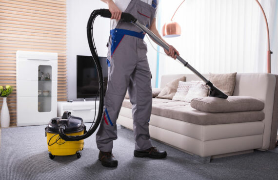 worker vacuuming a couch providing Professional Upholstery Cleaning in Gaithersburg, MD