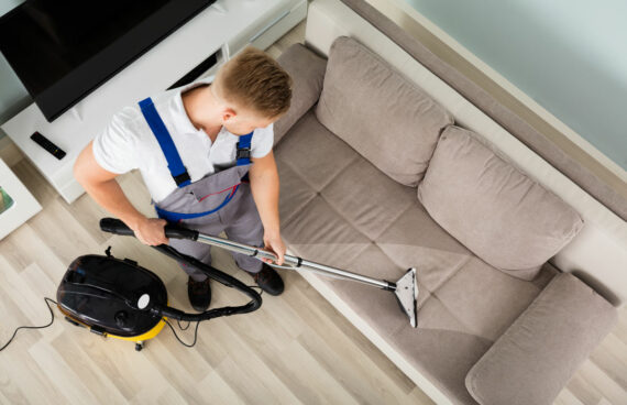 worker vacuuming a couch and performing Residential and Commercial Upholstery Cleaning in Gaithersburg, Maryland