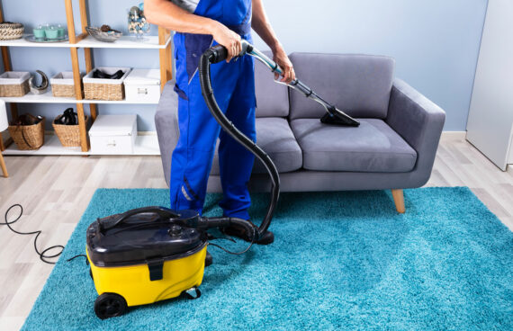 male worker vacuuming a couch providing Residential and Commercial Upholstery Cleaning in Gaithersburg, MD