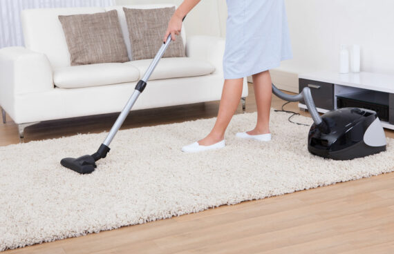 woman vacuuming a carpet providing Upholstery Cleaning and Carpet Cleaning Services in Gaithersburg, MD